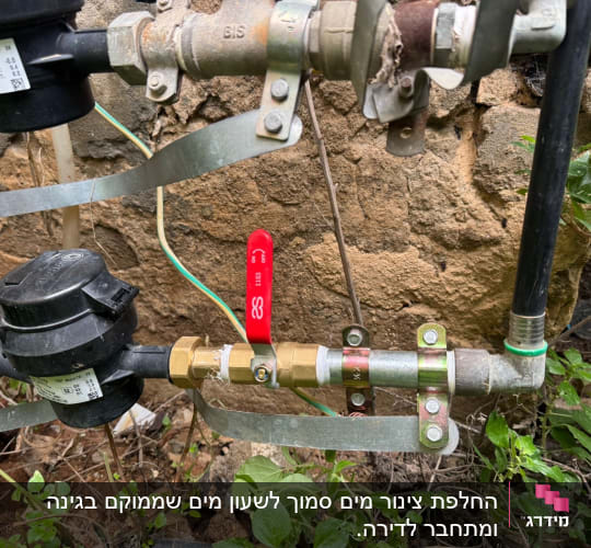 צנרת ומחברים עם שסתום אדום בגינה
